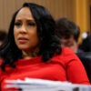 Fani Willis in a red outfit sits in a courtroom.