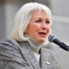 Tina Peters in a gray suit speaks during a rally.